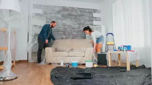 Couple Protecting Furniture with Plastic Cover